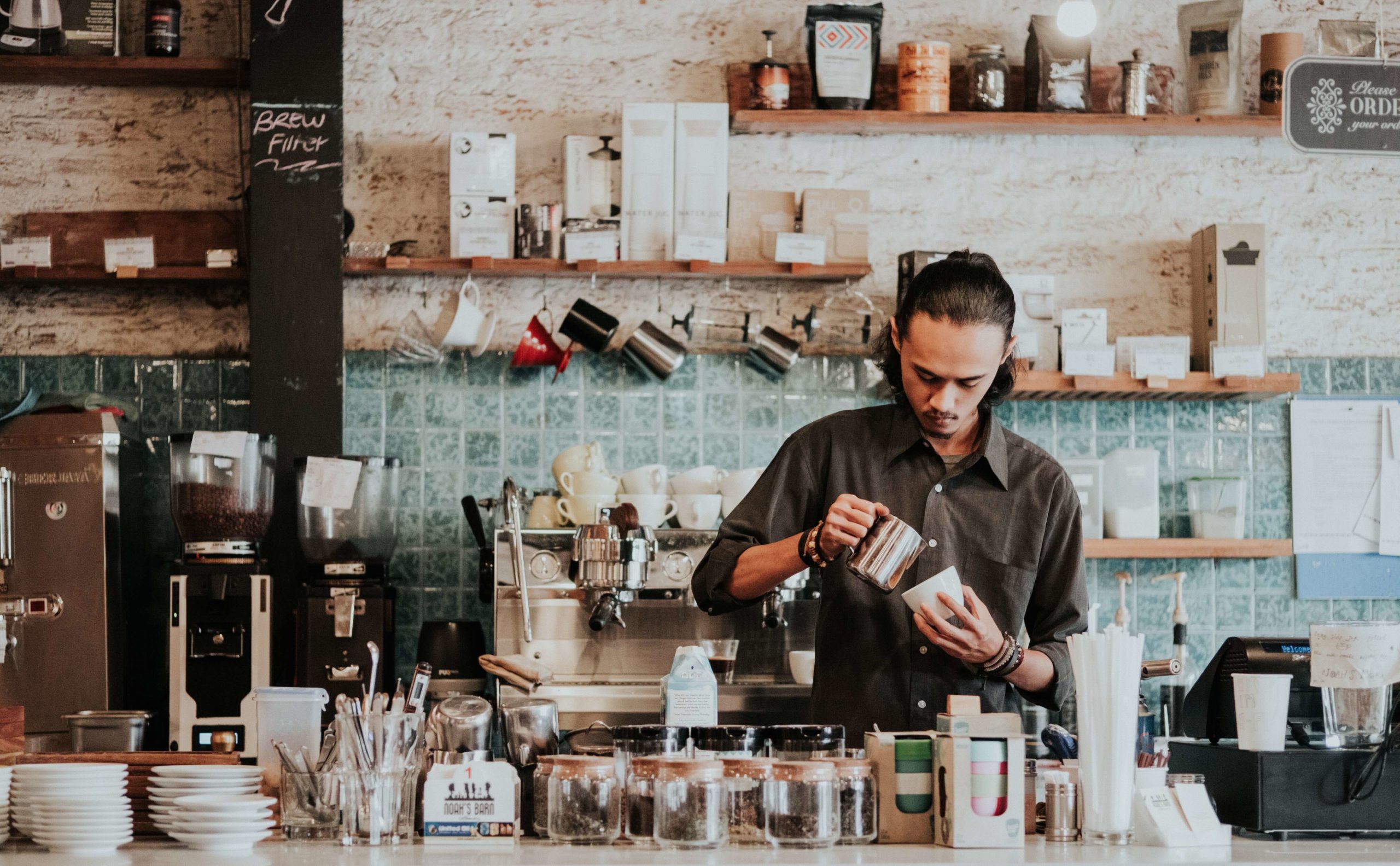 Mężczyzna robi kawę w nowoczesnej kawiarnii