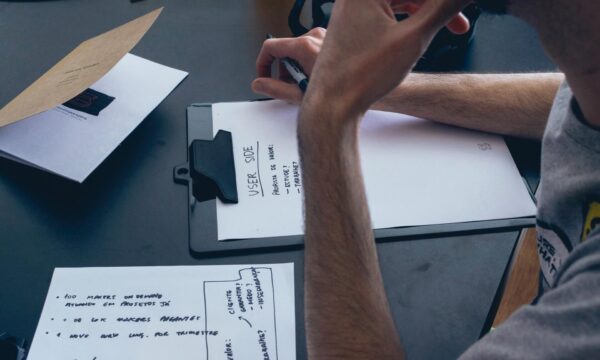 Mężczyzna zapisuje notatki. Tworzy mapę doświadczenia klientów
